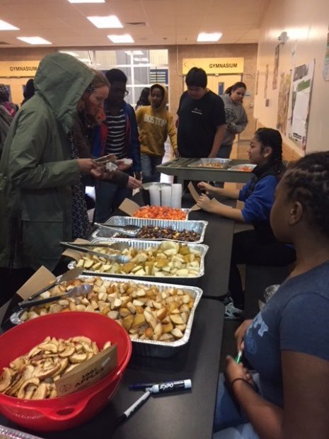 Tilth Alliance facilitates project-based learning with South Shore Students. 8 students line along a table with different samples of Washington produce.
